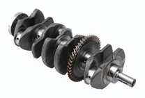 MONTTRON crankshaft: a four-cylinder crankshaft seen at an angle, with its counterweights, rod and main journals, the timing gear and the flywheel flange